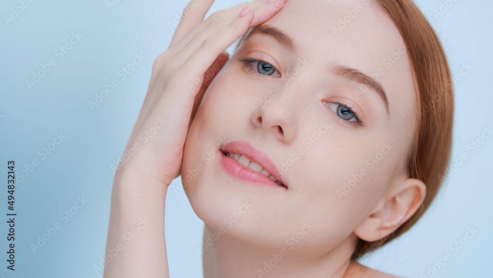 Close-up portrait of young ginger woman with perfect skin touches her hands and face, looks at camera | Beauty and skincare commercial concept Close-up portrait of young ginger woman with perfect skin touches her hands and face, looks at camera | Beauty and skincare commercial concept