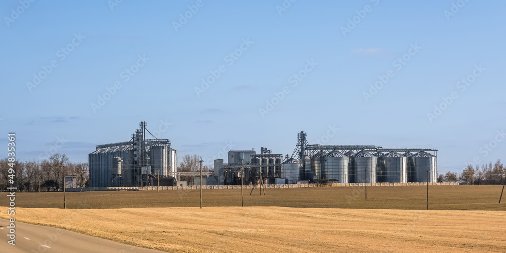 panorama view on agro silos granary elevator on agro-processing manufacturing plant for processing drying cleaning and storage of agricultural products, flour, cereals and grain. panorama view on agro silos granary elevator on agro-processing manufacturing plant for processing drying cleaning and storage of agricultural products, flour, cereals and grain.