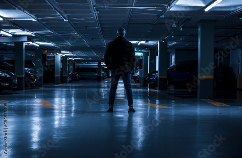 Rear view of adult man standing in underground parking lot. Madrid, Spain © WeeKwong