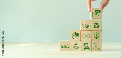 Low carbon,carbon neutral concept. Net zero greenhouse gas emissions target. Climate neutral long term strategy. Hand put wooden cubes with decrease carbon emission icon and green icon. Green banner.