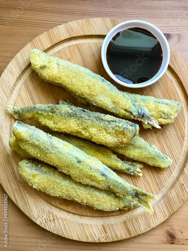 Pan fried fish on a plate. Capelin fried in oil with crispy breading.