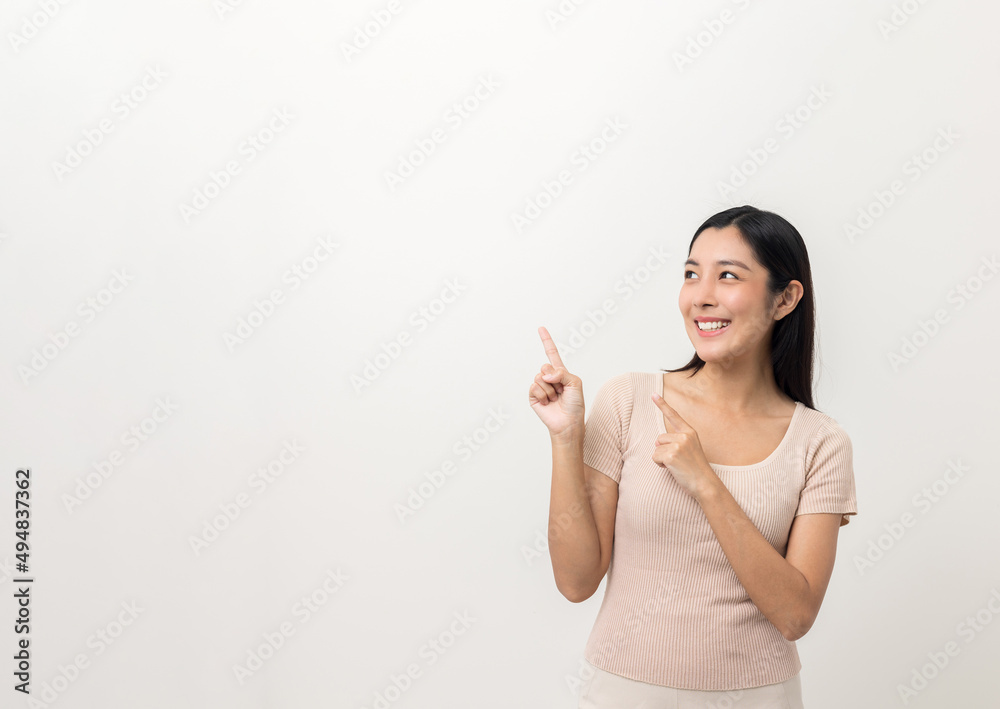Beautiful asian woman pointing finger into blank space. Smiling female standing pose on isolated white background. Attractive Teenager girl around 25 looking at empty space for advertise text. Beautiful asian woman pointing finger into blank space. Smiling female standing pose on isolated white background. Attractive Teenager girl around 25 looking at empty space for advertise text.