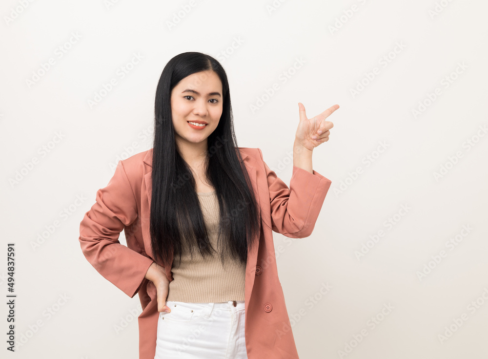 Beautiful asian women in pink fashion suit standing pose looking at camera pointing finger to blank space for advertise. Attractive Happy female portrait in white studio. Smiling woman age around 20 Beautiful asian women in pink fashion suit standing pose looking at camera pointing finger to blank space for advertise. Attractive Happy female portrait in white studio. Smiling woman age around 20