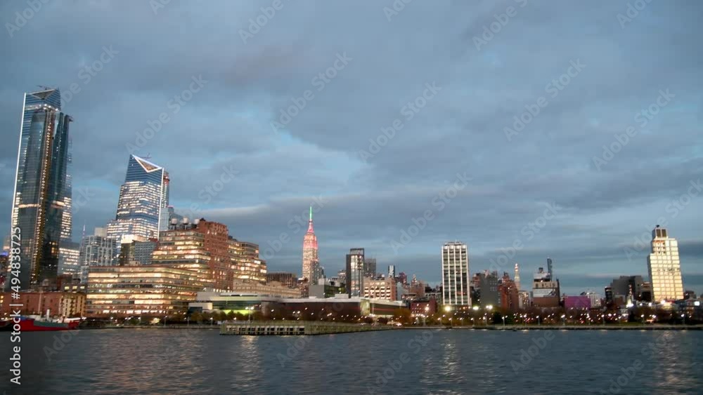 Midtown Manhattan and Hudson Yards lights. Sunset view of modern skyscrapers in New York City from the Hudson River Midtown Manhattan and Hudson Yards lights. Sunset view of modern skyscrapers in New York City from the Hudson River