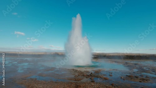 Geyser of Haukadalur in Iceland blowing-up erupting geothermal hot springs. Icelandic boiling geysers vapour and spray heated water. Wide angle shot. High quality 4k slow motion footage photo
