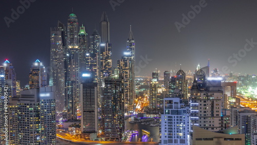 View of various skyscrapers in tallest recidential block in Dubai Marina aerial all night timelapse © neiezhmakov