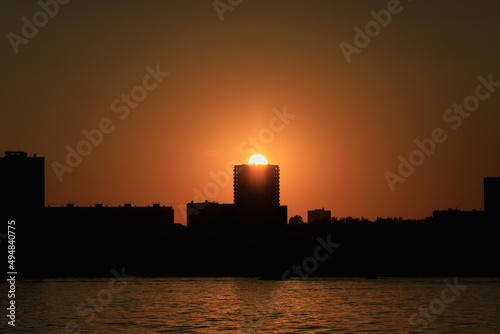 Sunset on city houses. The black silhouette of the city. Panorama citylandscape photo