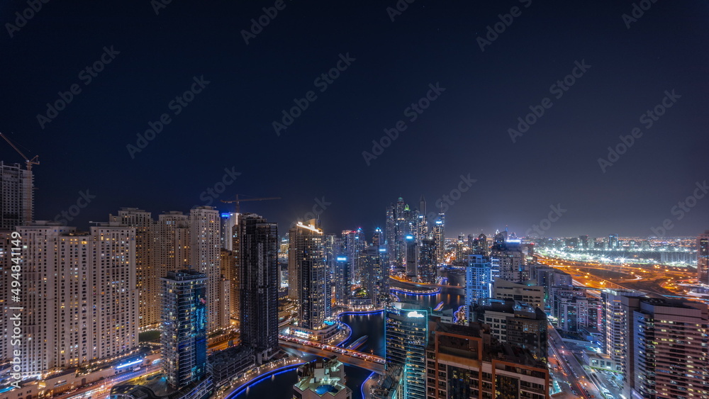 Panorama of various skyscrapers in tallest recidential block in Dubai Marina aerial all night timelapse