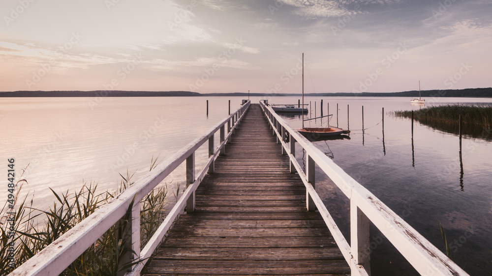 Morgendliche Ruhe an einem See mit langem Bootssteg horizontal
