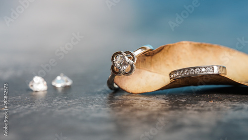 Closeup of a diamond engagement ring placed on a leaf. Love and wedding concept. 