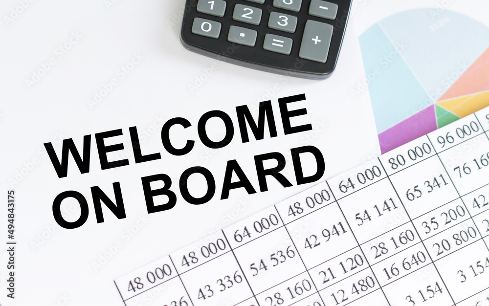 Welcome on board inscription on notepad on the table next to calculator and reports Welcome on board inscription on notepad on the table next to calculator and reports