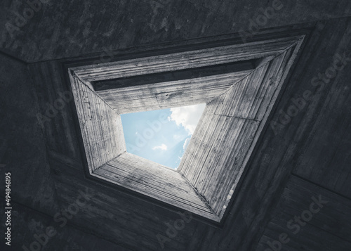 Looking up at the sky through pentagonal shaped light well. Concrete brutalist architecture photo