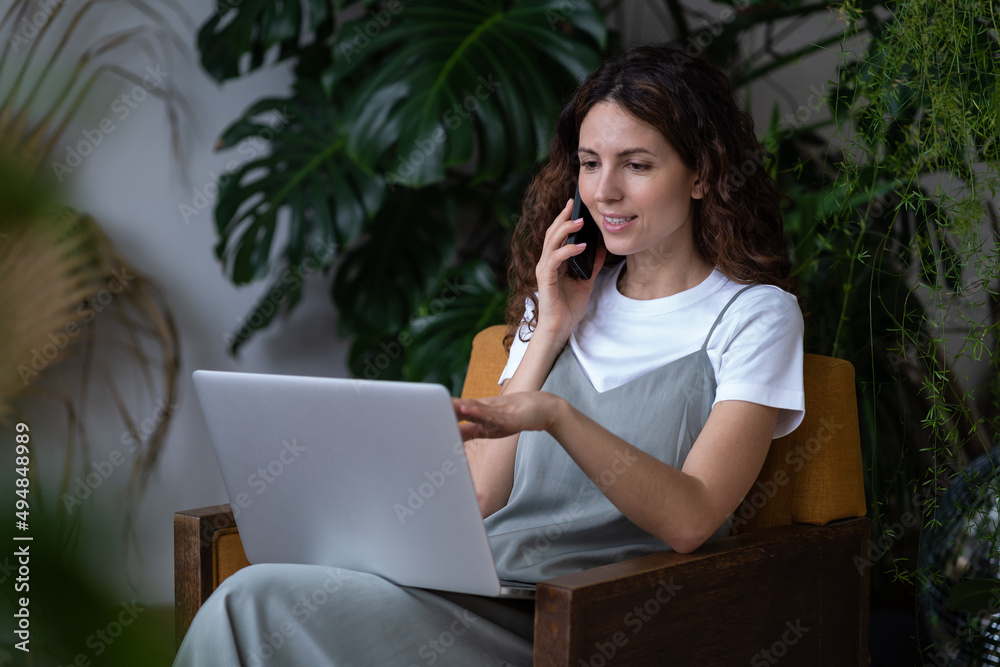 Young woman freelancer florist make phone call to online plants retail store buying new houseplants for indoor garden work from home. Female businesswoman entrepreneur talk with client on smartphone Young woman freelancer florist make phone call to online plants retail store buying new houseplants for indoor garden work from home. Female businesswoman entrepreneur talk with client on smartphone