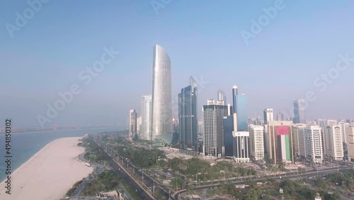 Abu Dhabi aerial skyline, beach and promenade on a sunny day, going up in the sky with a drone photo