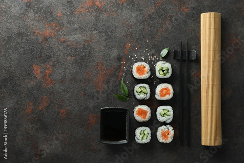 Concept of tasty food with maki on dark textured background