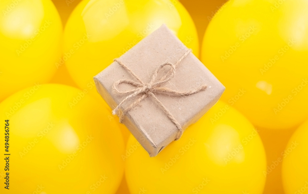 Gift box on a yellow background with balloons.Top view. space for text Gift box on a yellow background with balloons.Top view. space for text