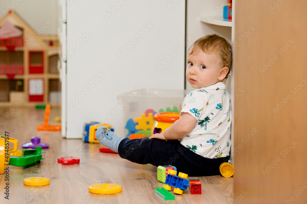 Baby playing with toys. Which toy to choose? baby checking toy box content. Baby playing with toys. Which toy to choose? baby checking toy box content.