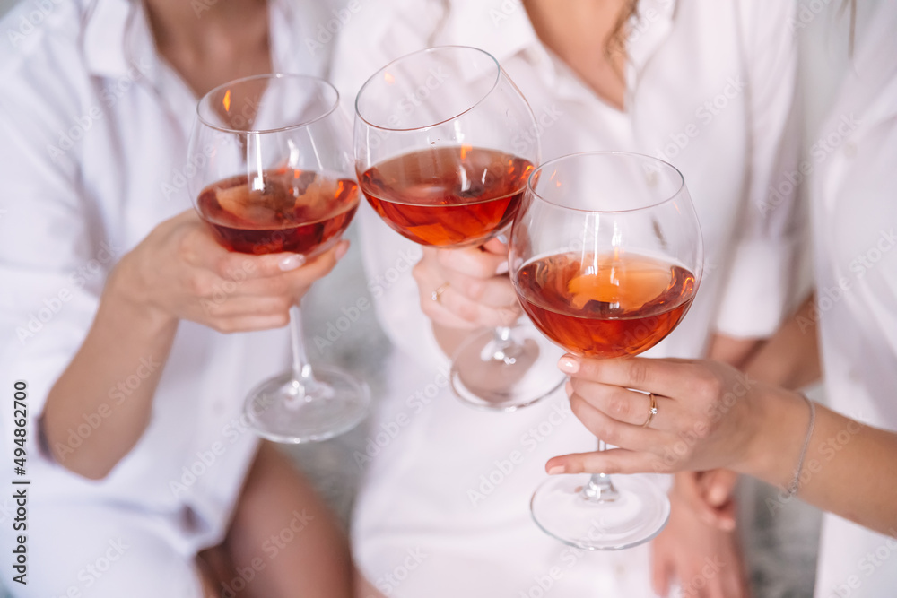 bride with best bridesmaids hold glasses and drink champagne in hotel room. Details of the wedding morning. bride with best bridesmaids hold glasses and drink champagne in hotel room. Details of the wedding morning.