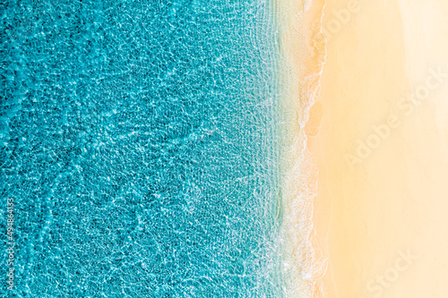 Relaxing aerial beach scene, summer vacation holiday template banner. Waves surf with amazing blue ocean lagoon, sea shore, coastline. Perfect aerial drone top view. Peaceful bright beach, seaside