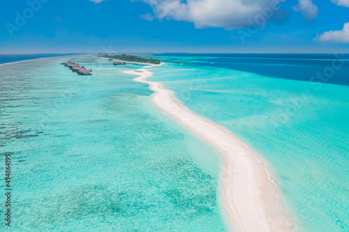 Panoramic landscape seascape aerial view over a Maldives atoll islands. White sandy beach seen from above. Perfect aerial landscape, luxury tropical resort or hotel with water villas beautiful beach