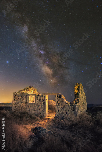 Vertical shot of an old abandoned broken ancient building in the background of a starry sky. photo