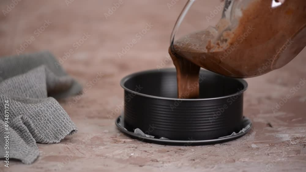 Chocolate Cake Batter Being Poured into Greased Cake Pan. Chocolate Cake Batter Being Poured into Greased Cake Pan.