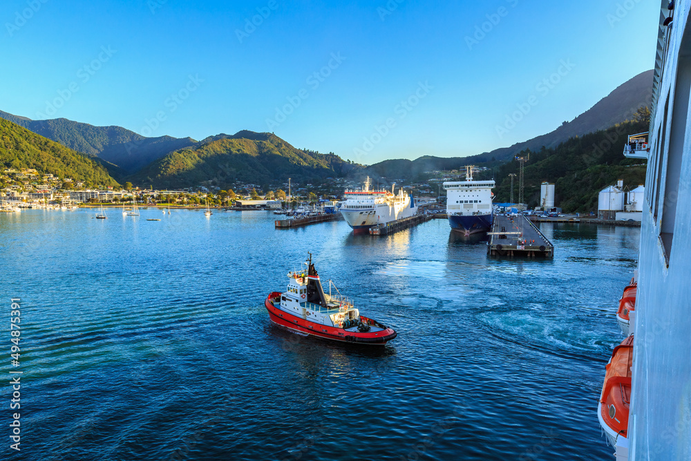 View of the town of Picton, New Zealand, from a cruise liner in Queen Charlotte Sound. A tugboat is returning to port