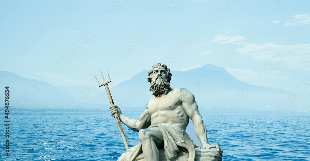 The mighty god of the sea and oceans Neptune (Poseidon) against sea and mountain landscape. The ancient statue.
