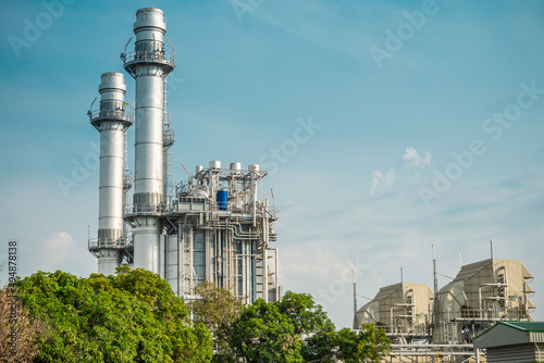 Natural gas electric power plant with blue sky sunny day background. Electricity, energy technology concept.