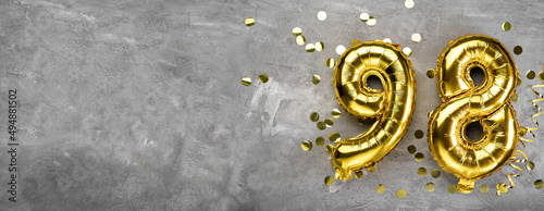 Yellow foil balloon number, number ninety-eight on a concrete background. Greeting card with the inscription 98. Anniversary concept. for anniversary, birthday, new year celebration. banner, © mtrlin