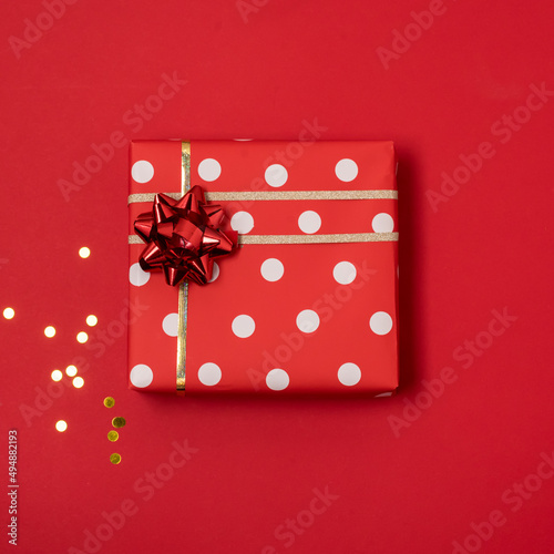 Composition With Gifts Boxes Wrapped in Red Wrapping Paper with a Gold Ribbon Red Background Top View