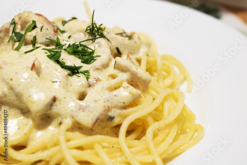 Pasta carbonara with cheese on a white plate