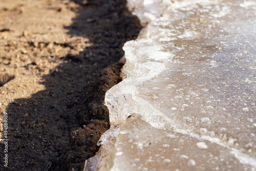 Edge of ice on the sand on the beach