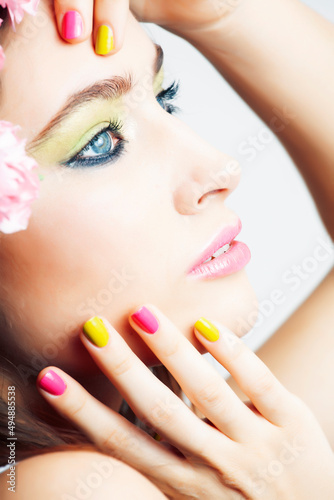 Beauty young real woman with pink flowers and make up closeup, spa salon, womans day concept