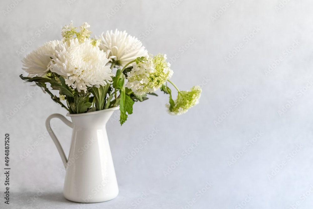 Flower in a white ceramic vase on a gray background. White chrysanthemums in a vase. Photo