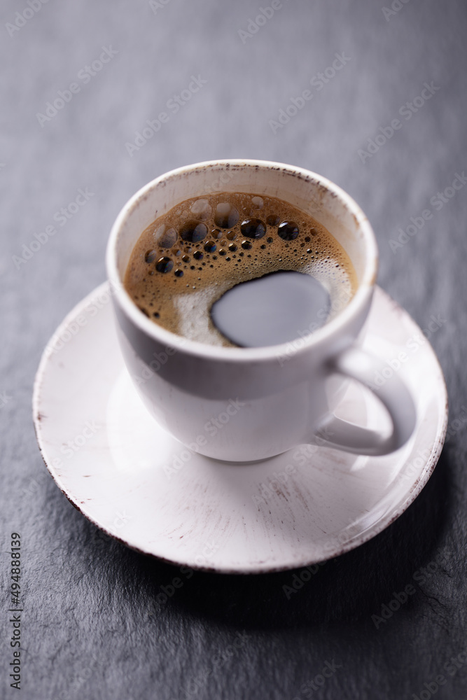 Cup of coffee on dark stone background. Close up. Cup of coffee on dark stone background. Close up.