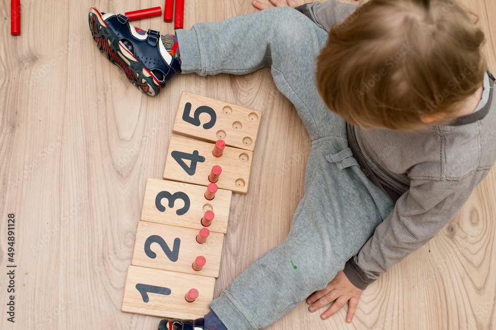 Obraz premium Wooden figures of the Montessori methodology. Math kids counting puzzle for kids. Educational training in computing games to develop. An intelligent children's math toy. Number game board.