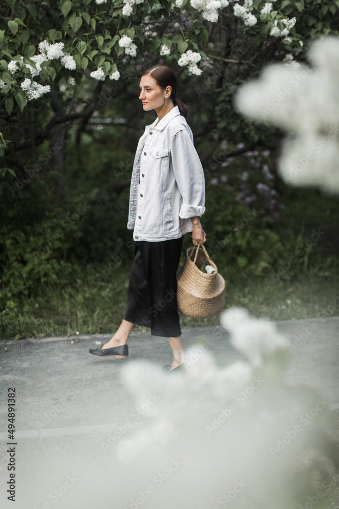 woman holding a basket of white lilacs in her hands