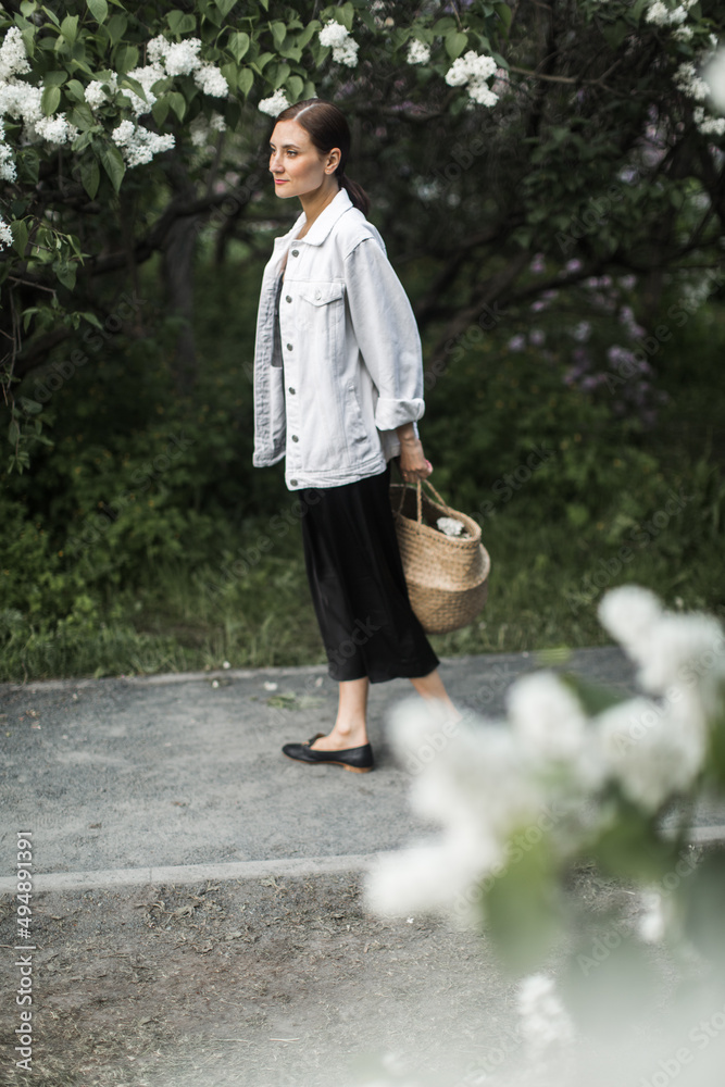 woman holding a basket of white lilacs in her hands