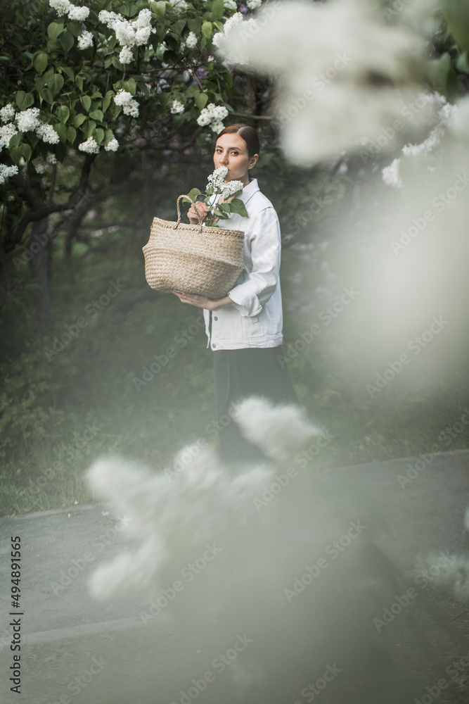young woman with a basket of white lilacs