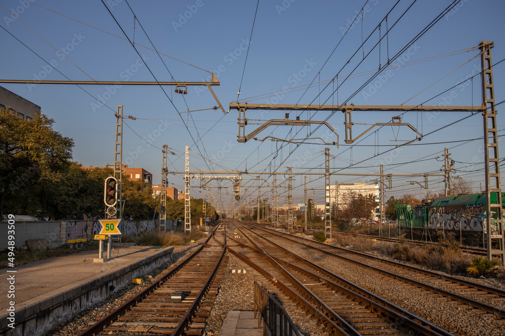 Train tracks and power pylons at a Spanish train station near Barcelona. rails and sleepers close up.