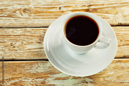 Coffee in a white ceramic mug. Coffee on an old wooden table. Copy space and free space for text near food.