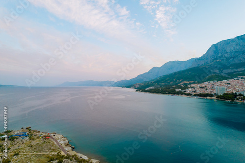 Fototapeta Naklejka Na Ścianę i Meble -  Panoramic top view of the sea and the modern resort town with high hotels near the rocky mountains.