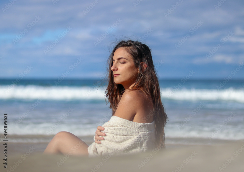Beautiful brunette woman with eyes closedsunbathing on the beach and having cold Beautiful brunette woman with eyes closedsunbathing on the beach and having cold