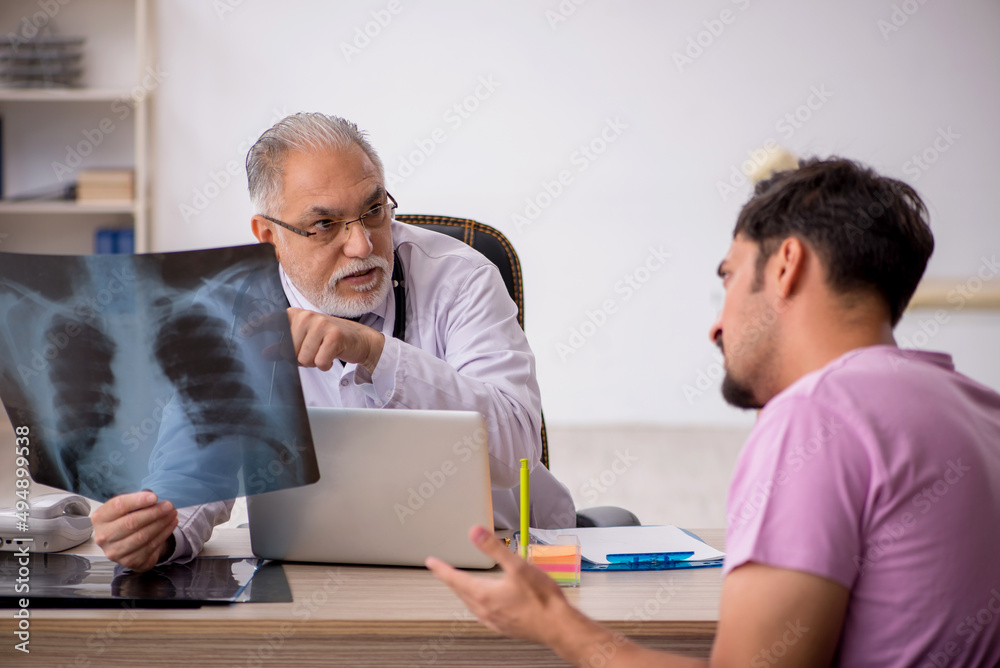 Young male patient visiting old male doctor radiologist Young male patient visiting old male doctor radiologist