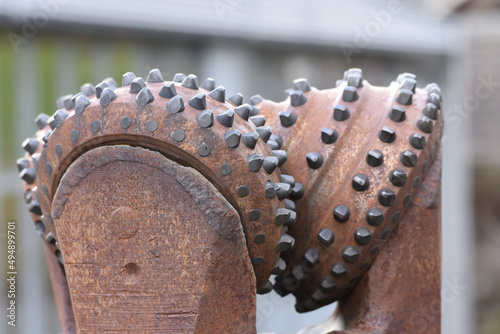 Closeup of a rusty metallic drill bit on a blurry gray background photo