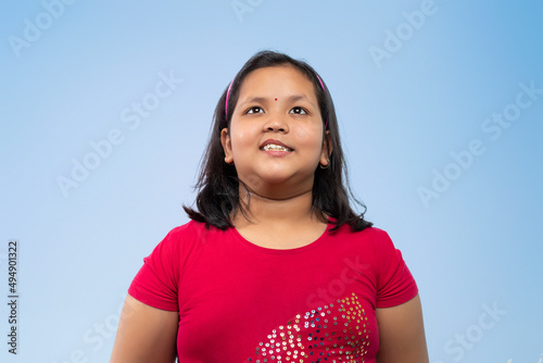 Portrait of girl looking up isolated on a Blue background