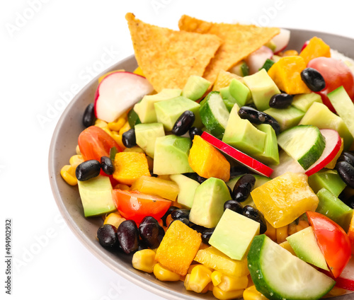 Bowl of tasty Mexican vegetable salad with black beans and radish on white background, closeup