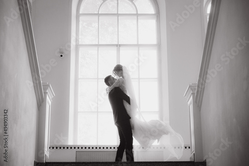 Wedding of a beautiful, stylish couple, a bride in a white wedding dress and a groom in a black suit, tuxedo.
