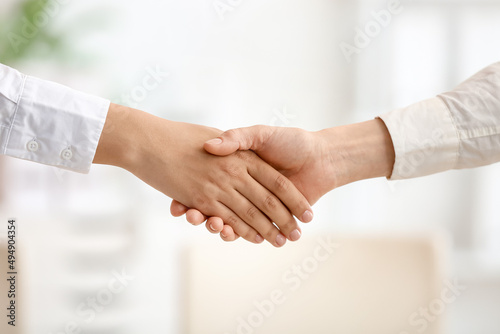 Businesswomen shaking hands during meeting in office